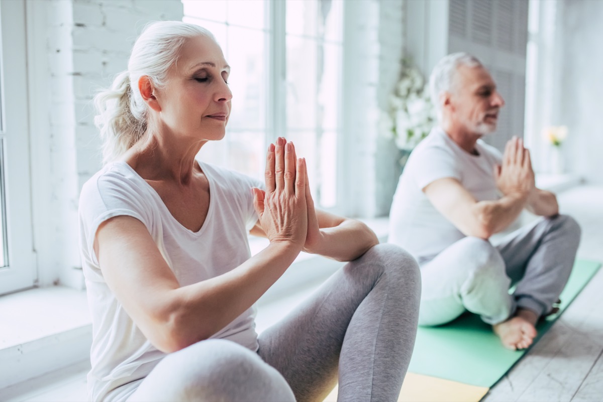 Senior couple is doing physical training at home.