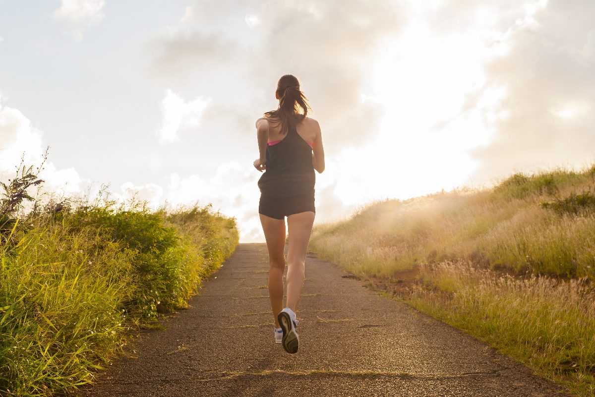 woman jogging uphill on a sunny day