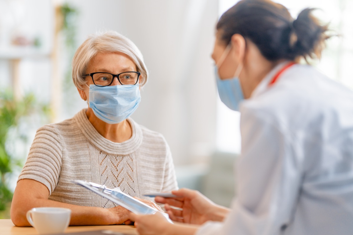 Doctor and elderly woman with face masks