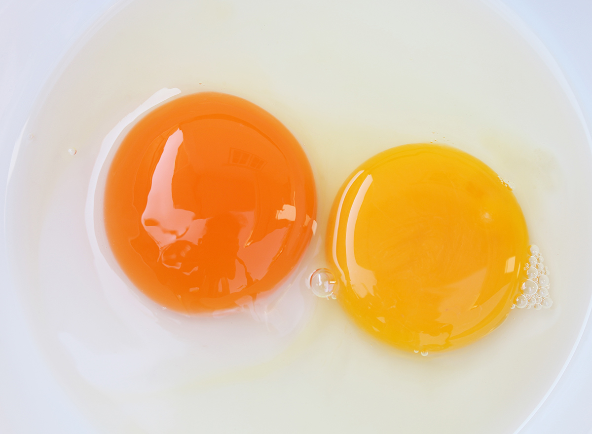 two different colors of egg yolk in a bowl