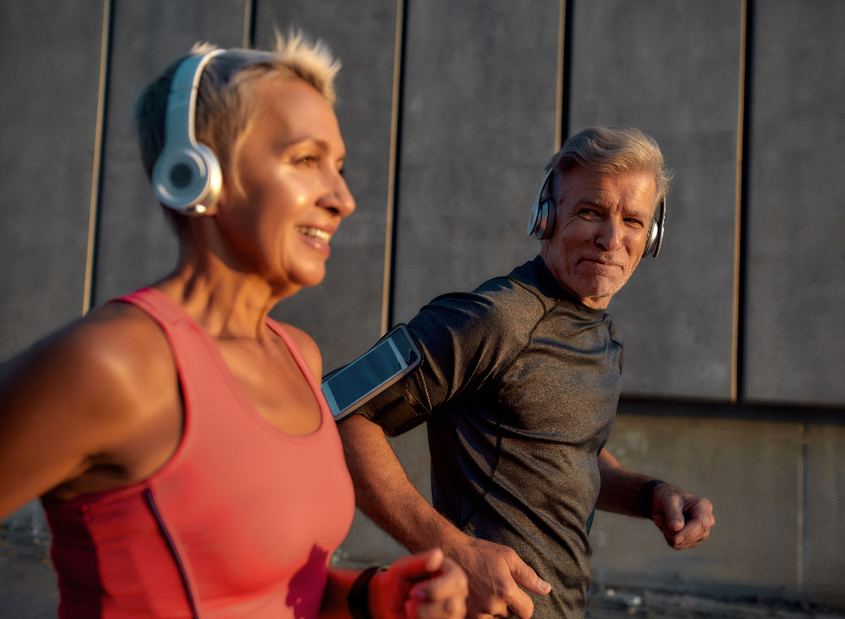 mature couple running outdoors at sunset, one of the leisure activities that lengthen your life