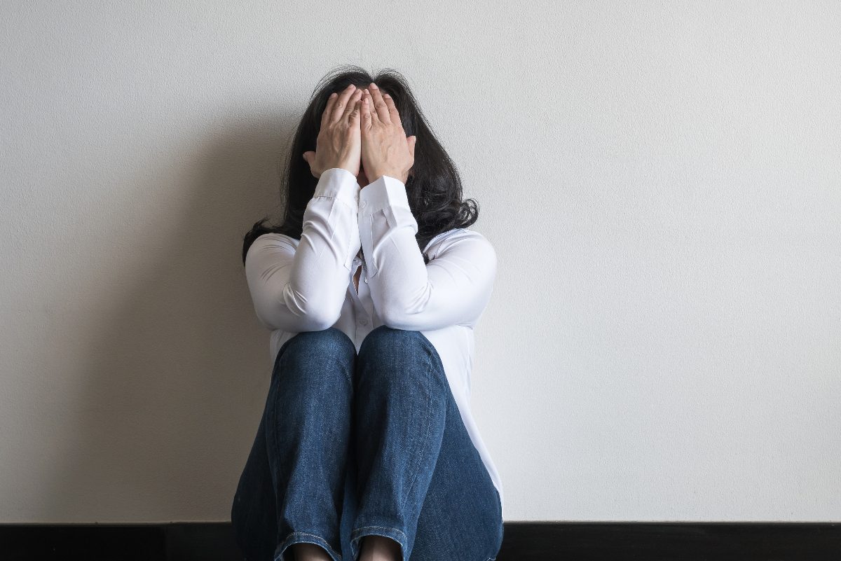 woman sitting on the floor at home dealing with a panic attack