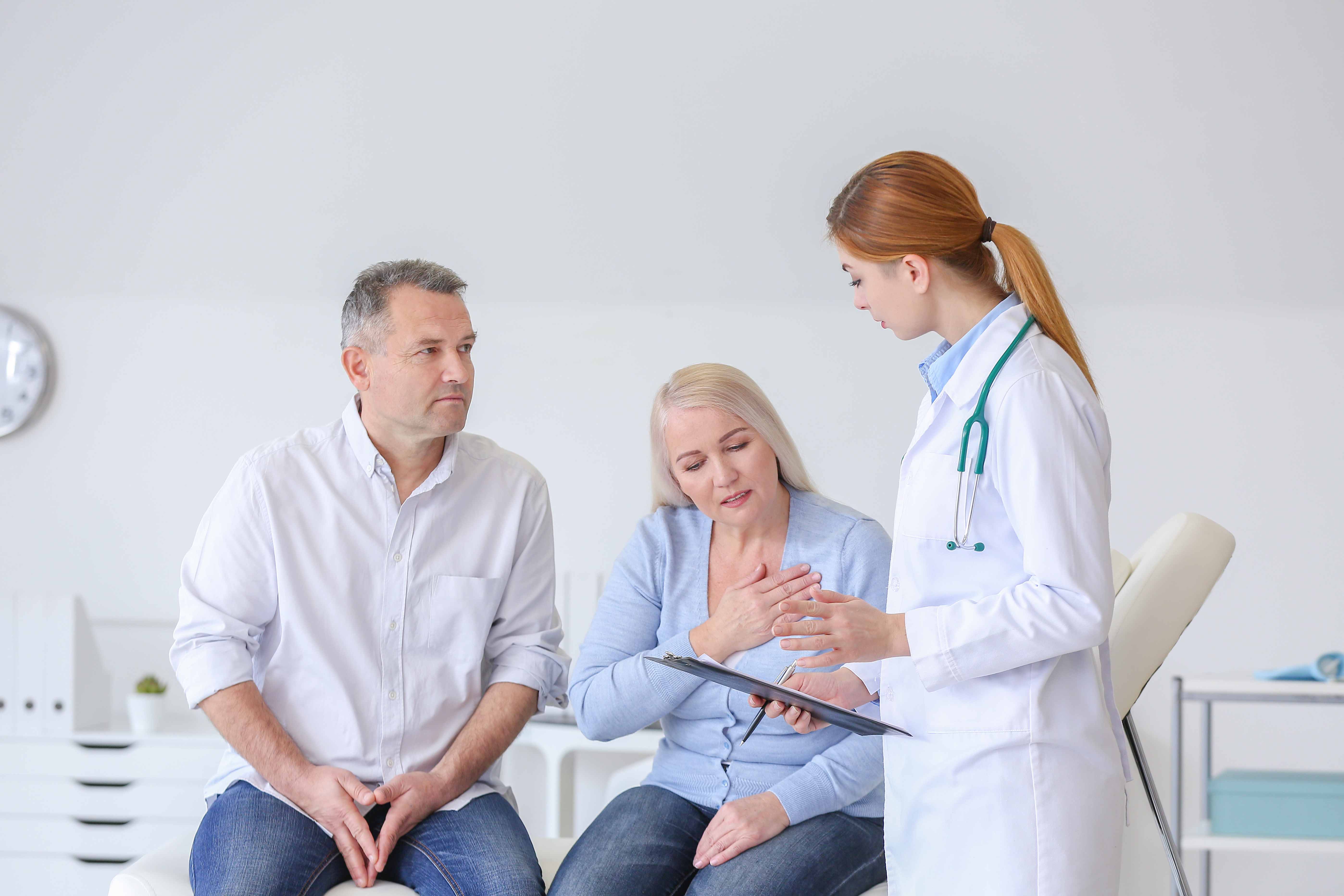 Middle-aged couple talking to a young doctor