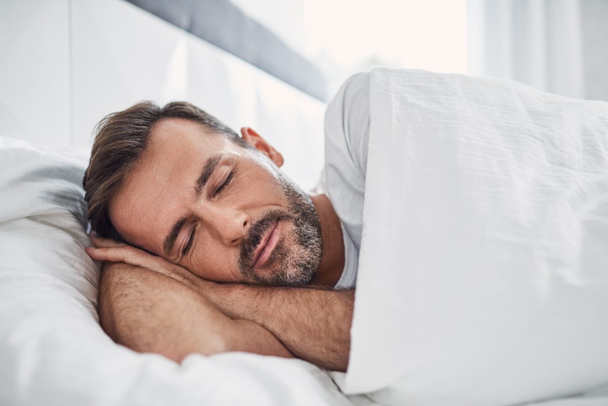 man sleeping in a bright room