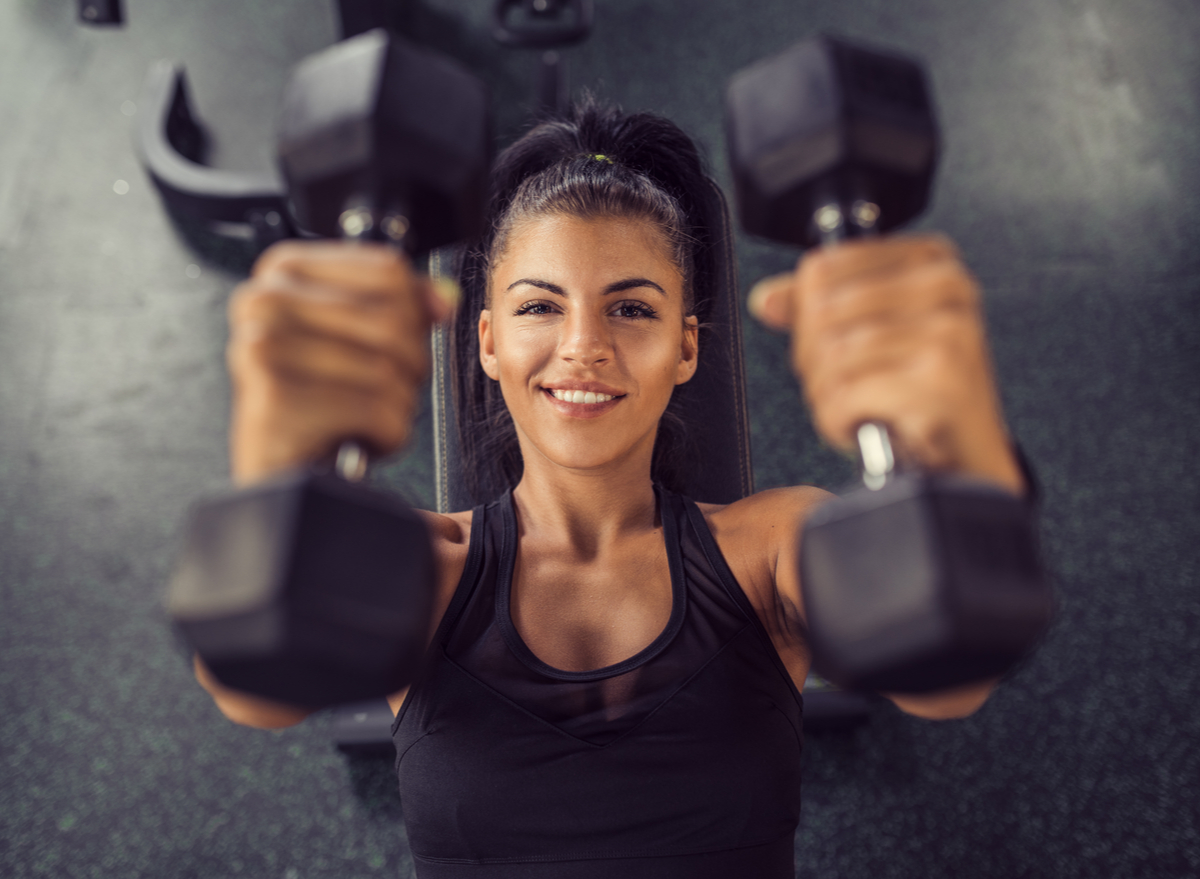 happy woman smiling gym weights