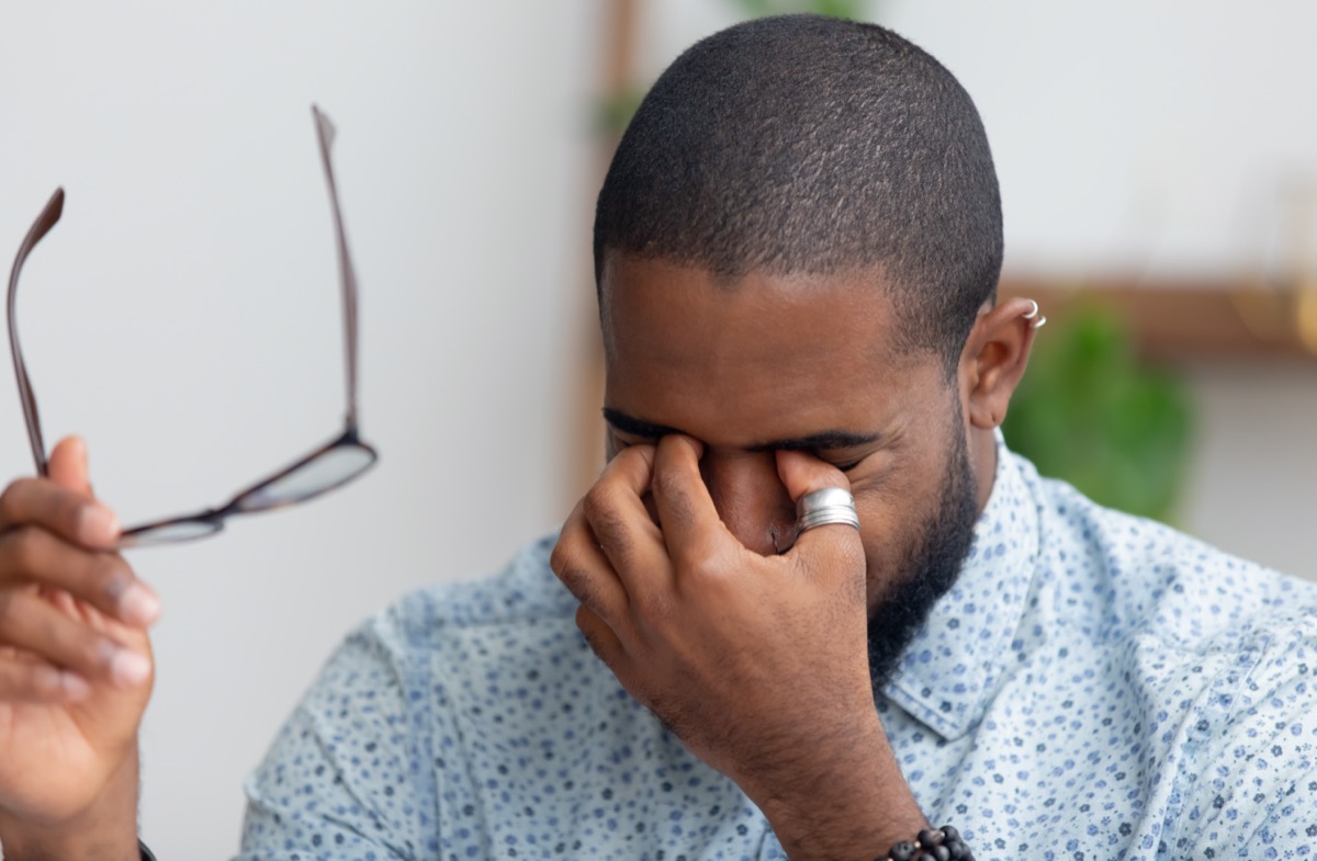 businessman taking off his glasses rubbing his sore eyes