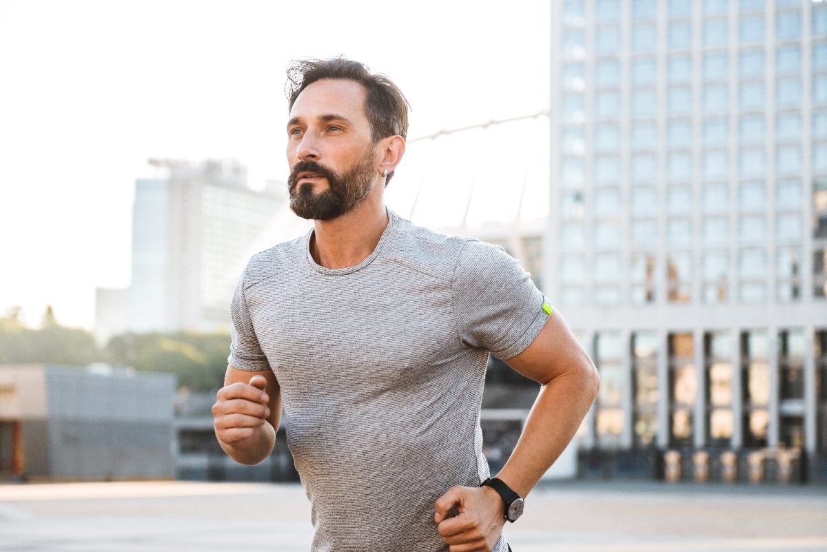 man in his 40s running outside in the city