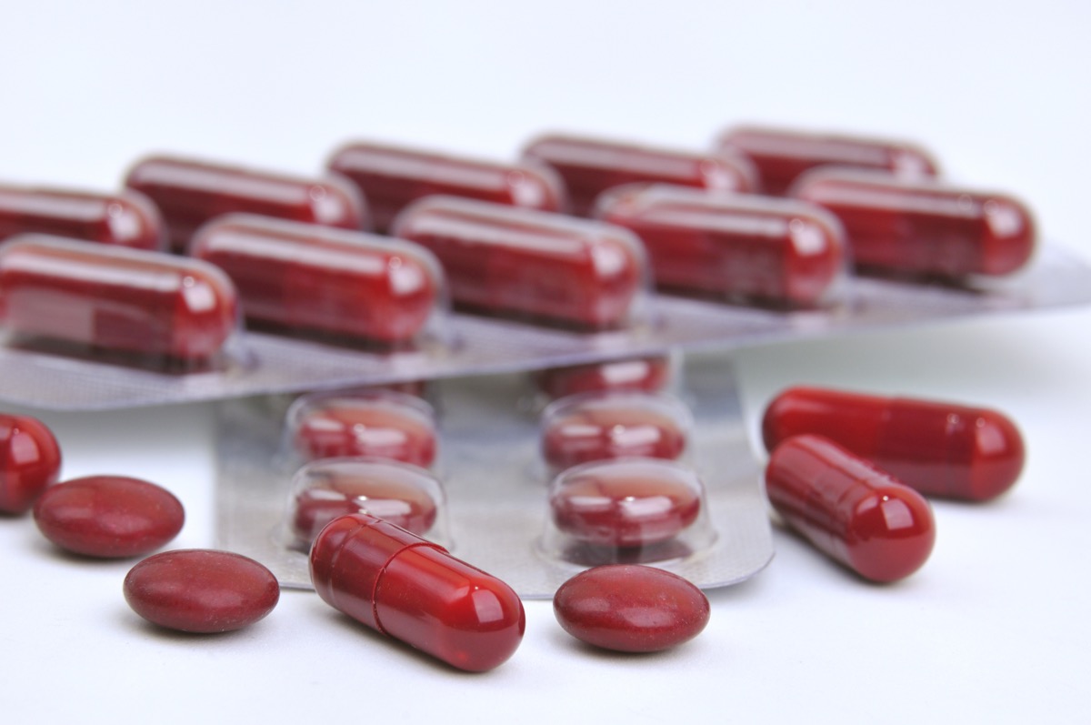 assortment of red pills and iron supplement capsules