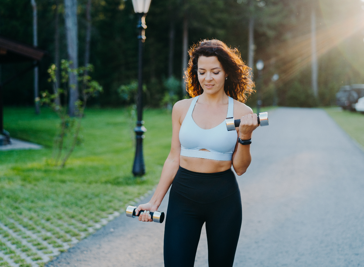 woman walks outside with weights