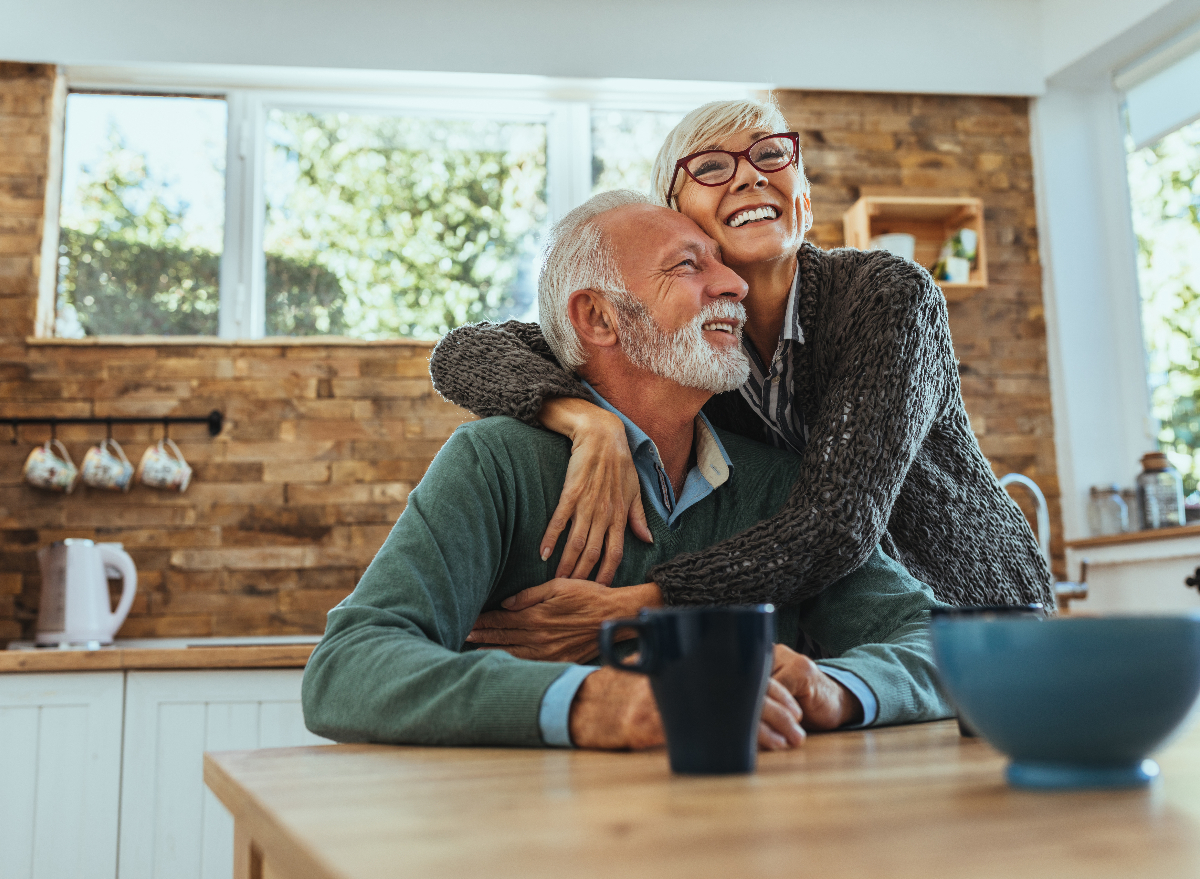 happy senior couple hug each other in the kitchen