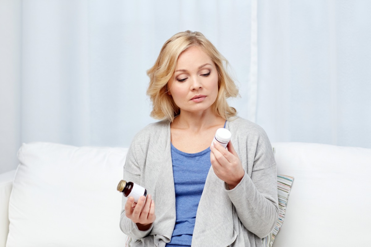 woman with medicine bottles at home