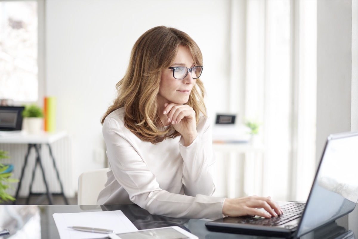 Mature businesswoman working on laptop at her workstation.