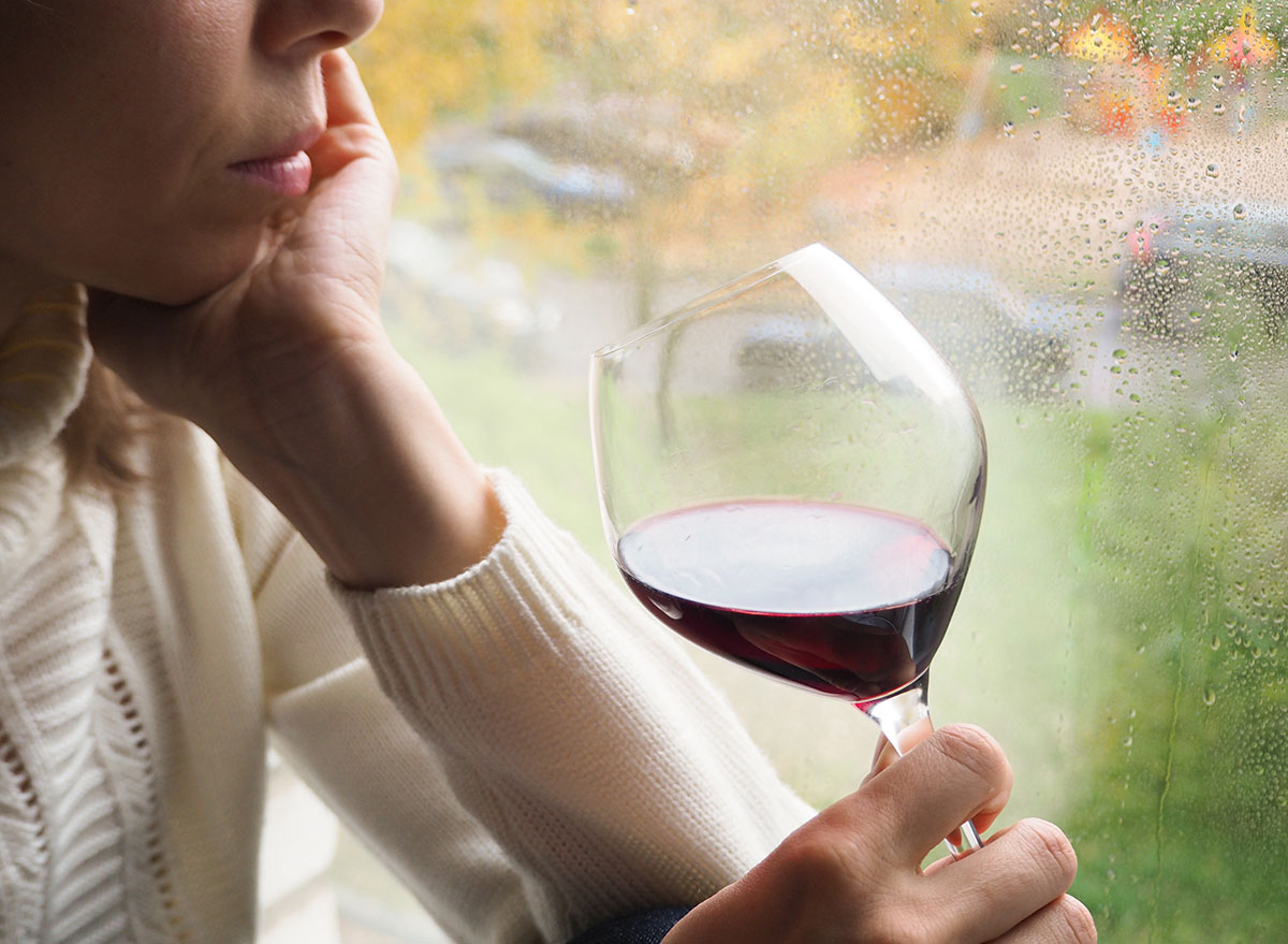 woman drinking wine by the window: how does alcohol affect the brain?