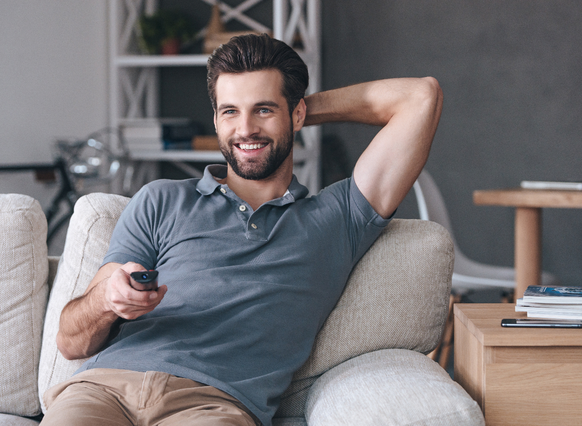 sedentary happy man watching tv