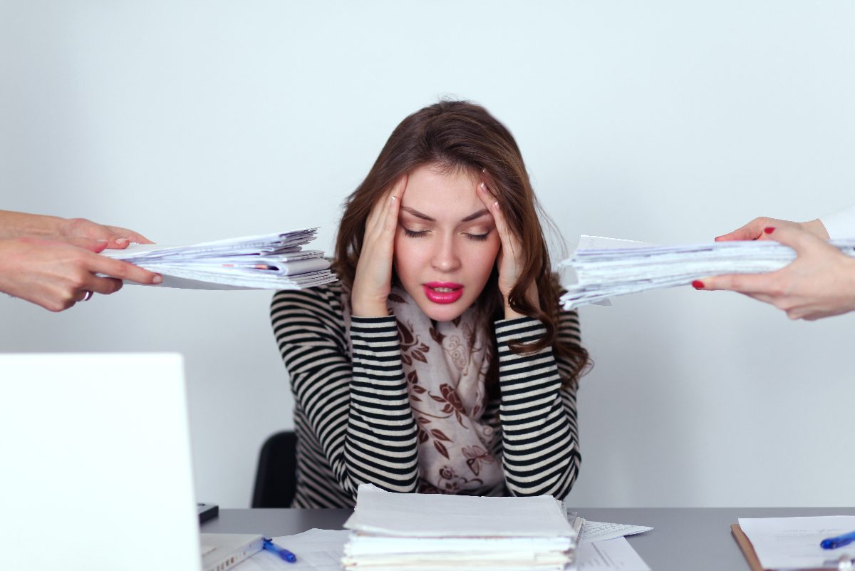 woman puts her hands on her head, stressed, busy at work