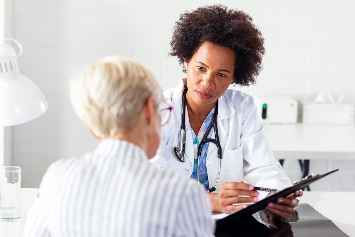 Mature woman with her doctor in ambulance discussing medical care