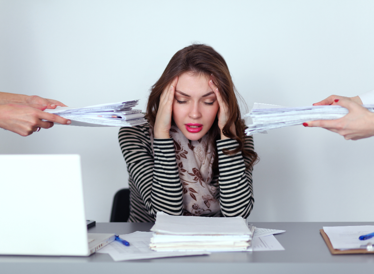 woman puts her hands on her head, stressed, busy at work