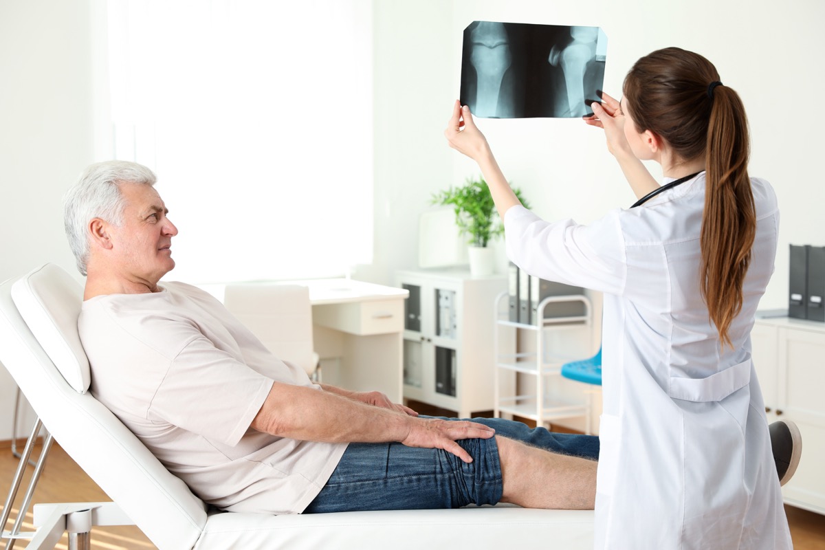 doctor with x-ray and senior patient in clinic.  knee problem