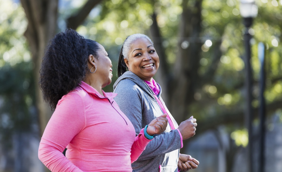 two middle aged black women walking outside together