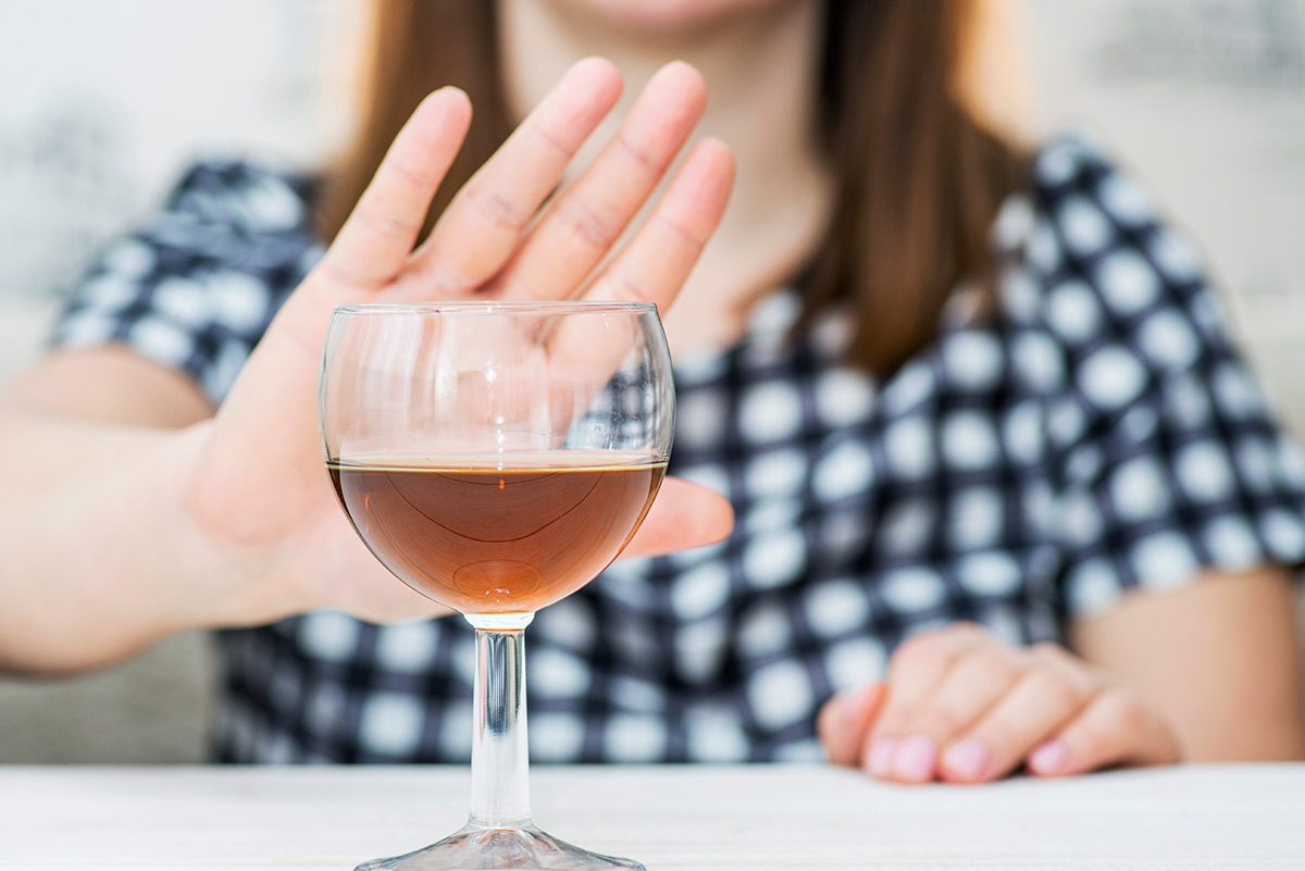 woman refusing a glass of alcohol