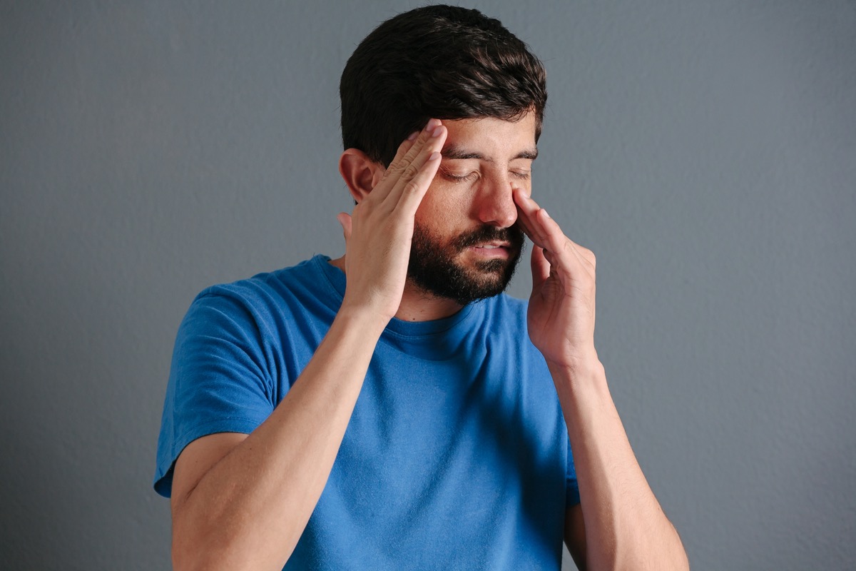 man holding his nose because sinusitis hurts