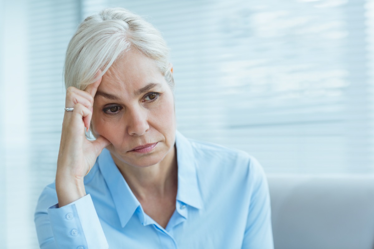 Sad senior woman looking away at home