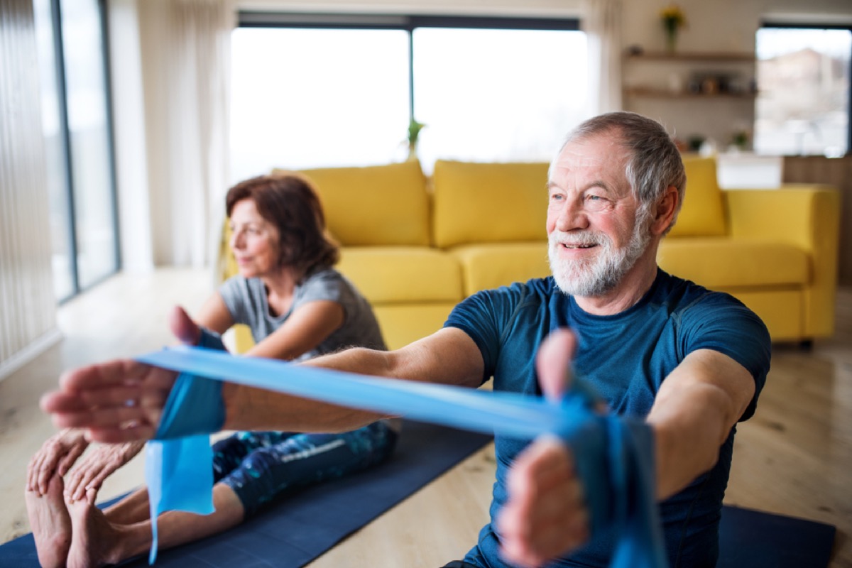 senior white man and woman exercising at home