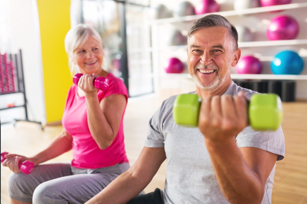 Senior couple exercising lifting weights