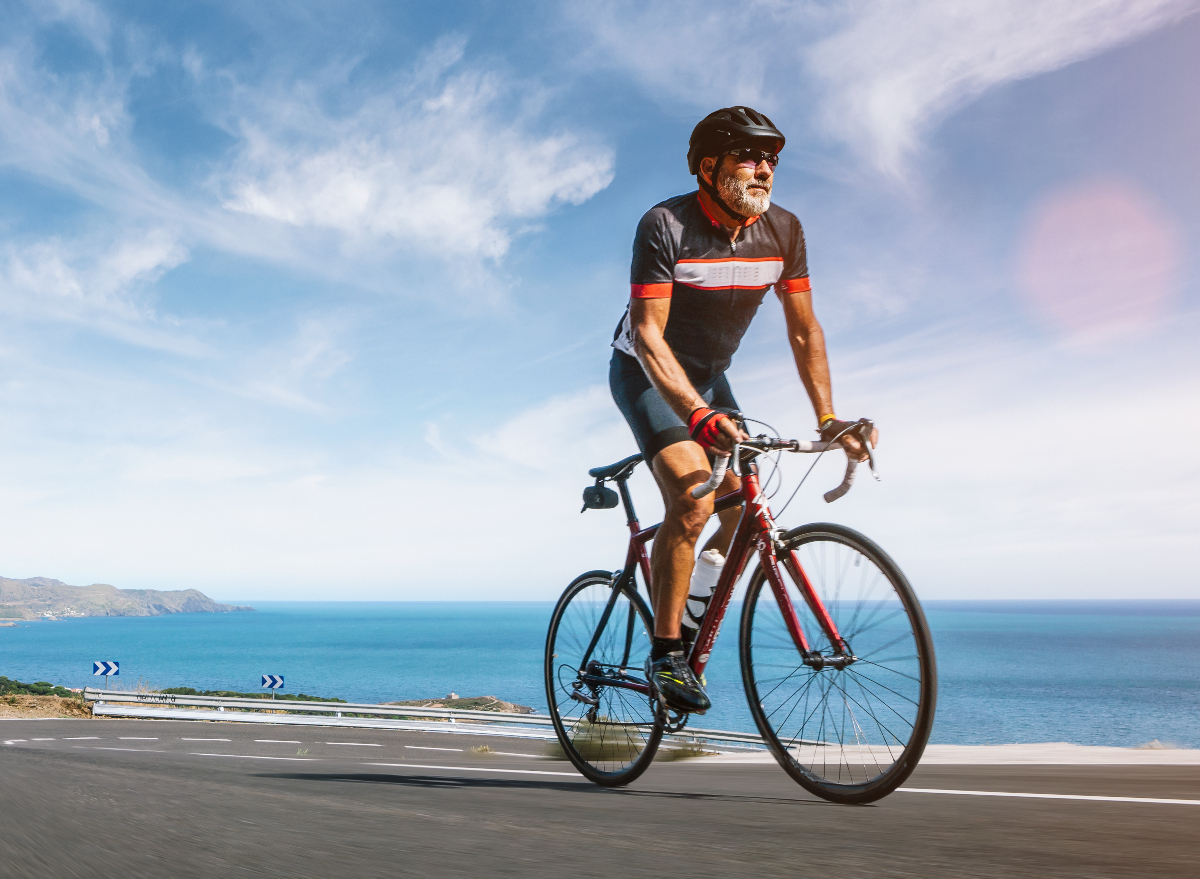 mature man on a bicycle running along the coast, exercise habits that delay aging