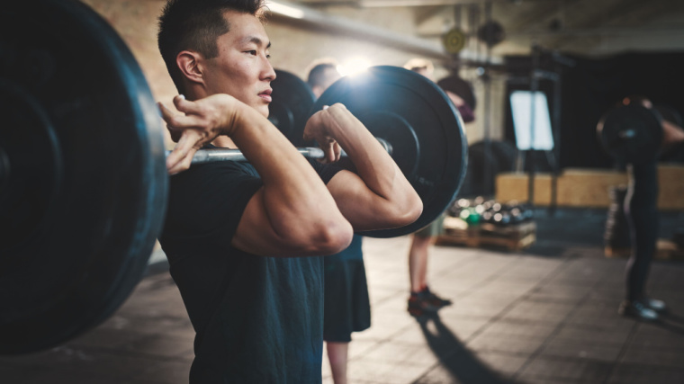 A person performs a front squat while staring straight ahead.