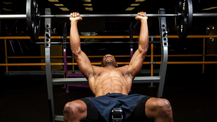 A person sets up to perform an incline barbenll bench press.