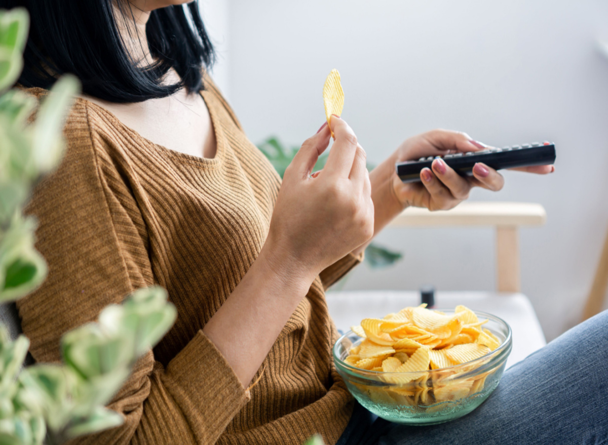 woman eating chips while watching tv