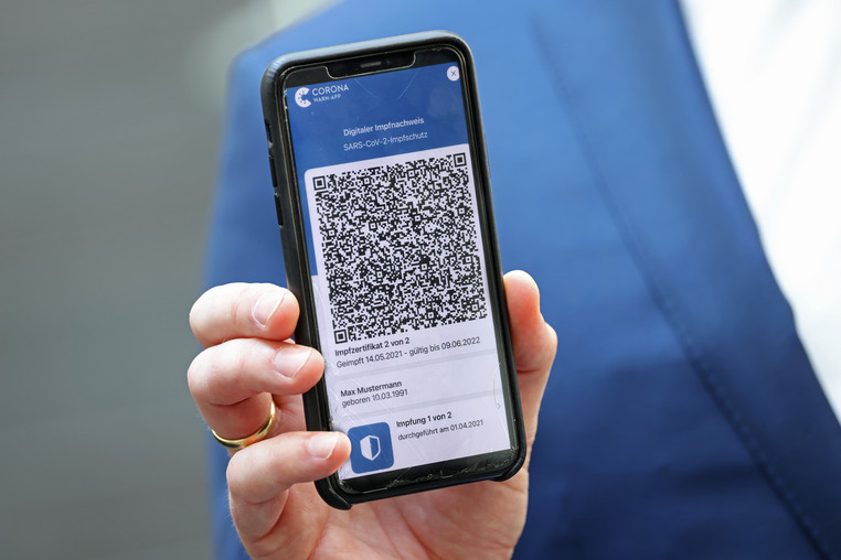 BERLIN, GERMANY - JUNE 10: German Health Minister Jens Spahn holds a smartphone with the digital CovPass Covid vaccination certificate on a smartphone via Germany's Corona Warn app on June 10, 2021 in Berlin, Germany .  CovPass will provide those who have been fully vaccinated against Covid-19 with international certification.  EU countries have been working on a common platform for digital certification of vaccines, in particular to promote international summer travel and tourism.  (Photo by Sean Gallup/Getty Images)