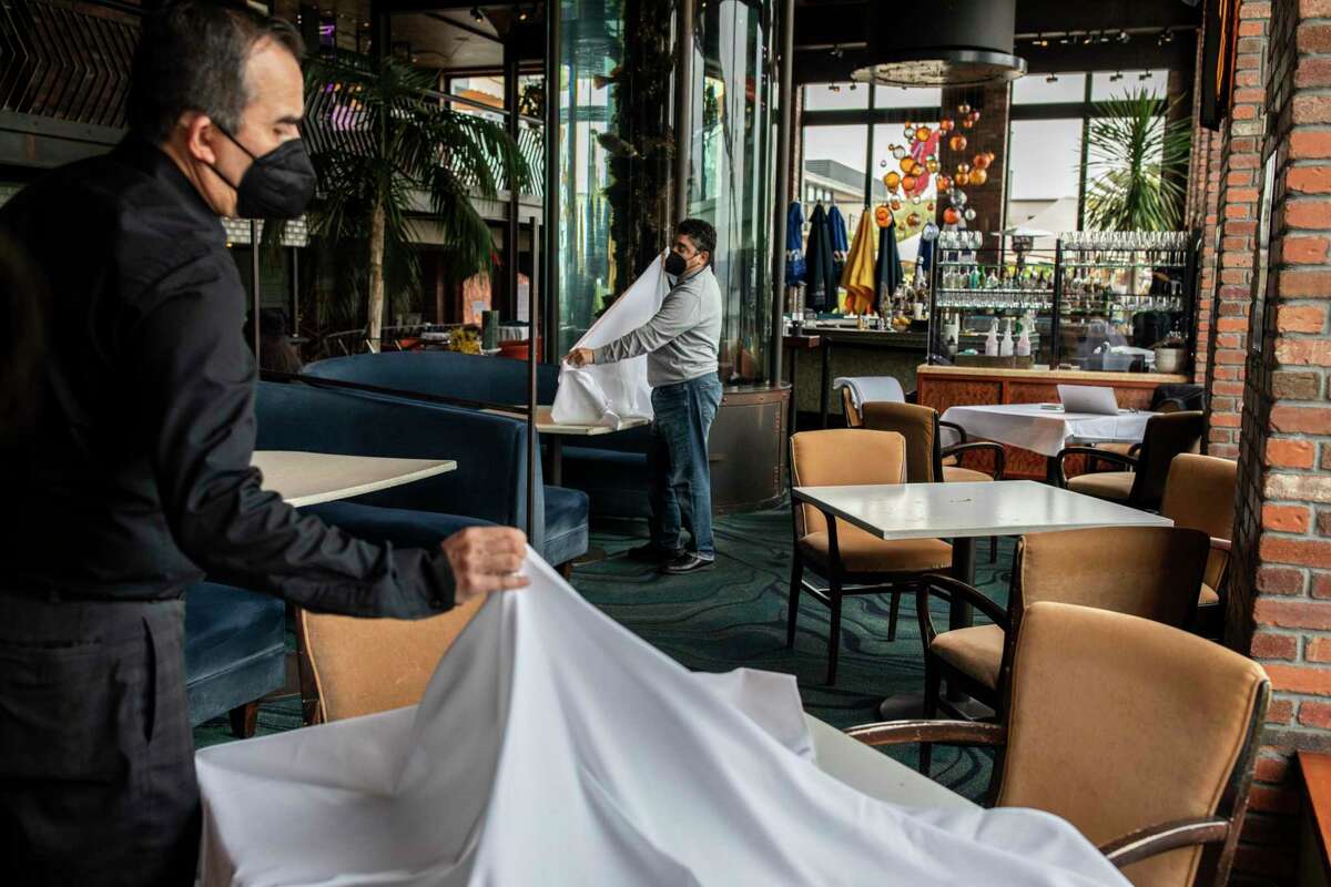 Ricardo Torres (left) and Rich Troiani set up tables at Waterbar on the Embarcadero in San Francisco in 2021.