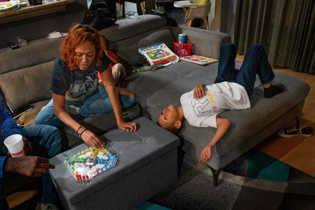 Seven-year-old Jagger looks up at his mom, Dallas Garcia, as they play the board game Trouble in February in their Stafford home. Jagger’s older brother, Fred Harris, loved playing board games even though his low IQ meant he didn’t always follow the rules. This is the first time the family has played board games together since Fred’s death last year.