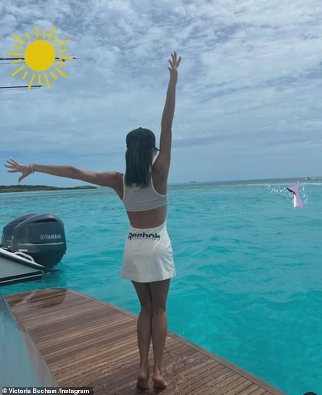 Stunning: It comes after Victoria looked in high spirits as she posed in a white Reebok skirt and matching sports bra on the back of a boat at a luxurious venue